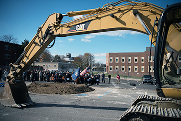 CAT fronthoe in foreground of Ground Breaking ceremony