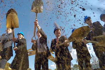 Participants at the Ground breaking ceremony throw dirt in the air with shovels