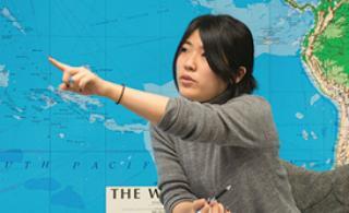 Student pointing to world map