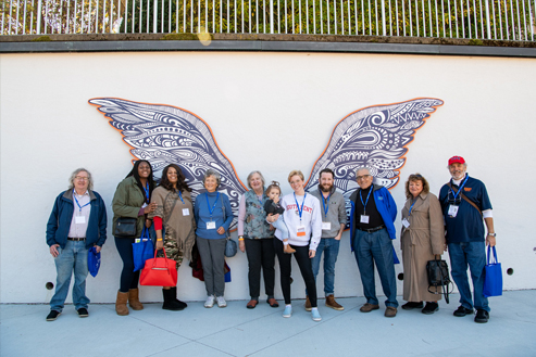 alumni in front of campus wing installation