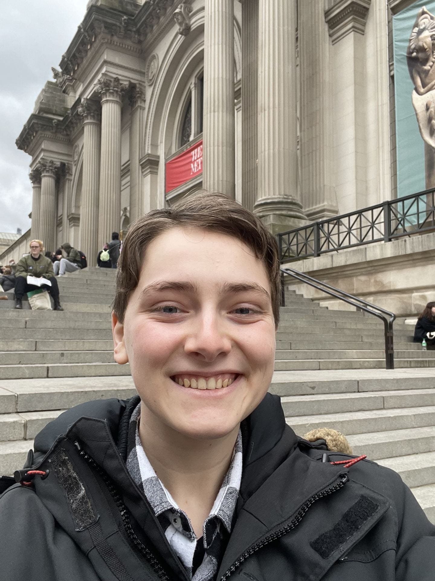 close up of a smiling young person on the steps of the Metropolitan Museum of Art