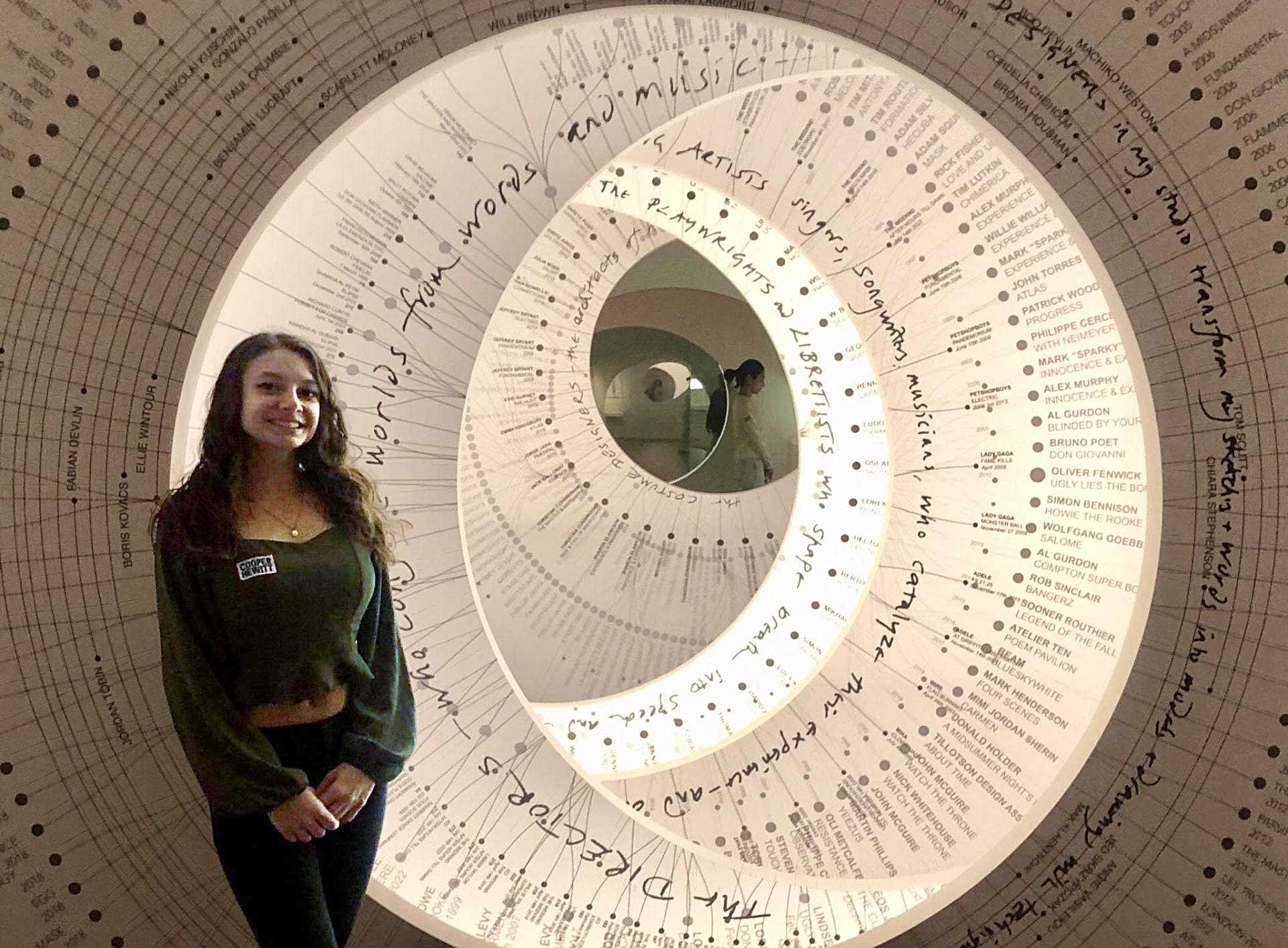 a smiling young intern standing in front of a work by artist Es Devlin at the Cooper Hewitt Museum of Design