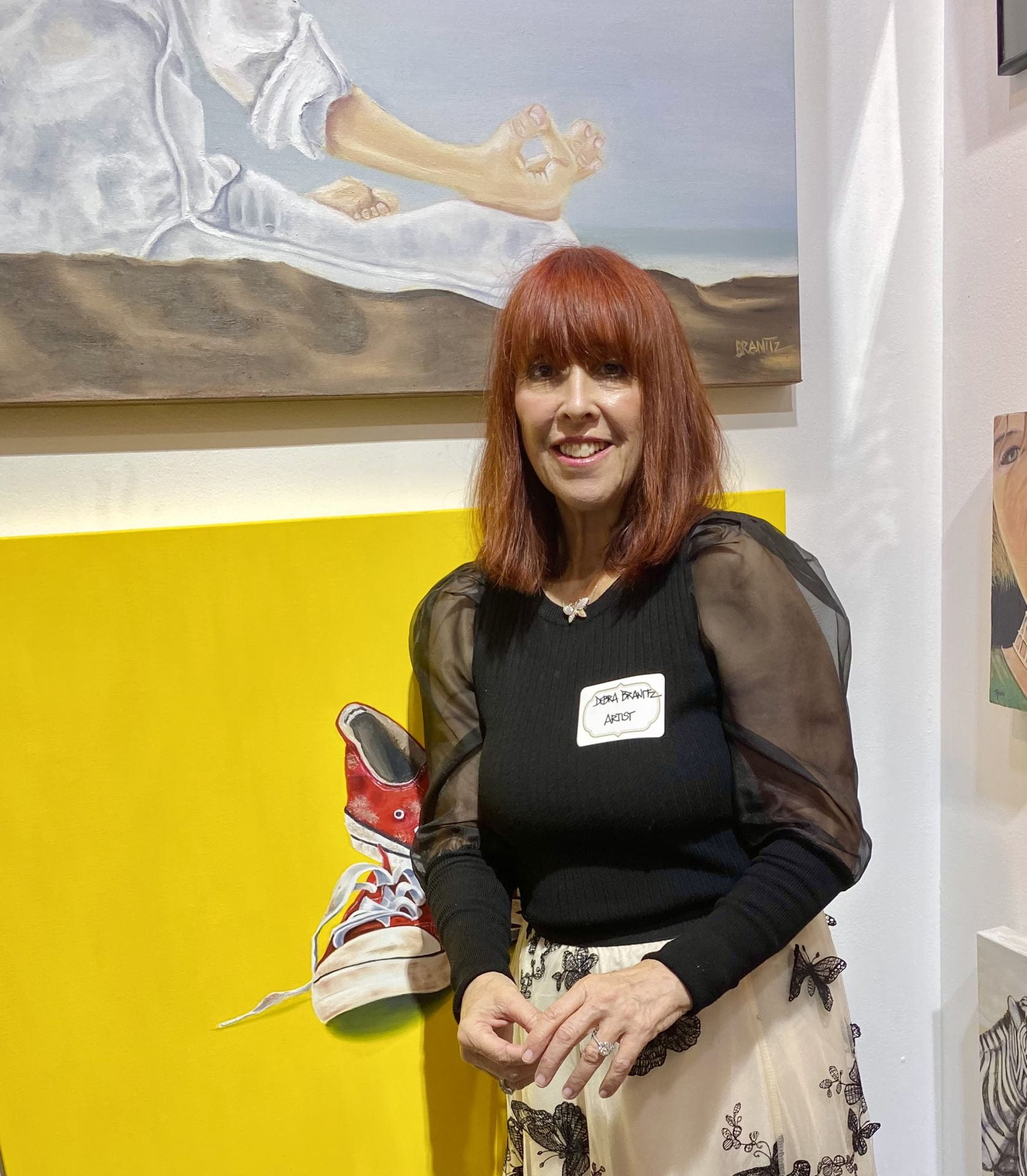 woman with red hair in front of a painting