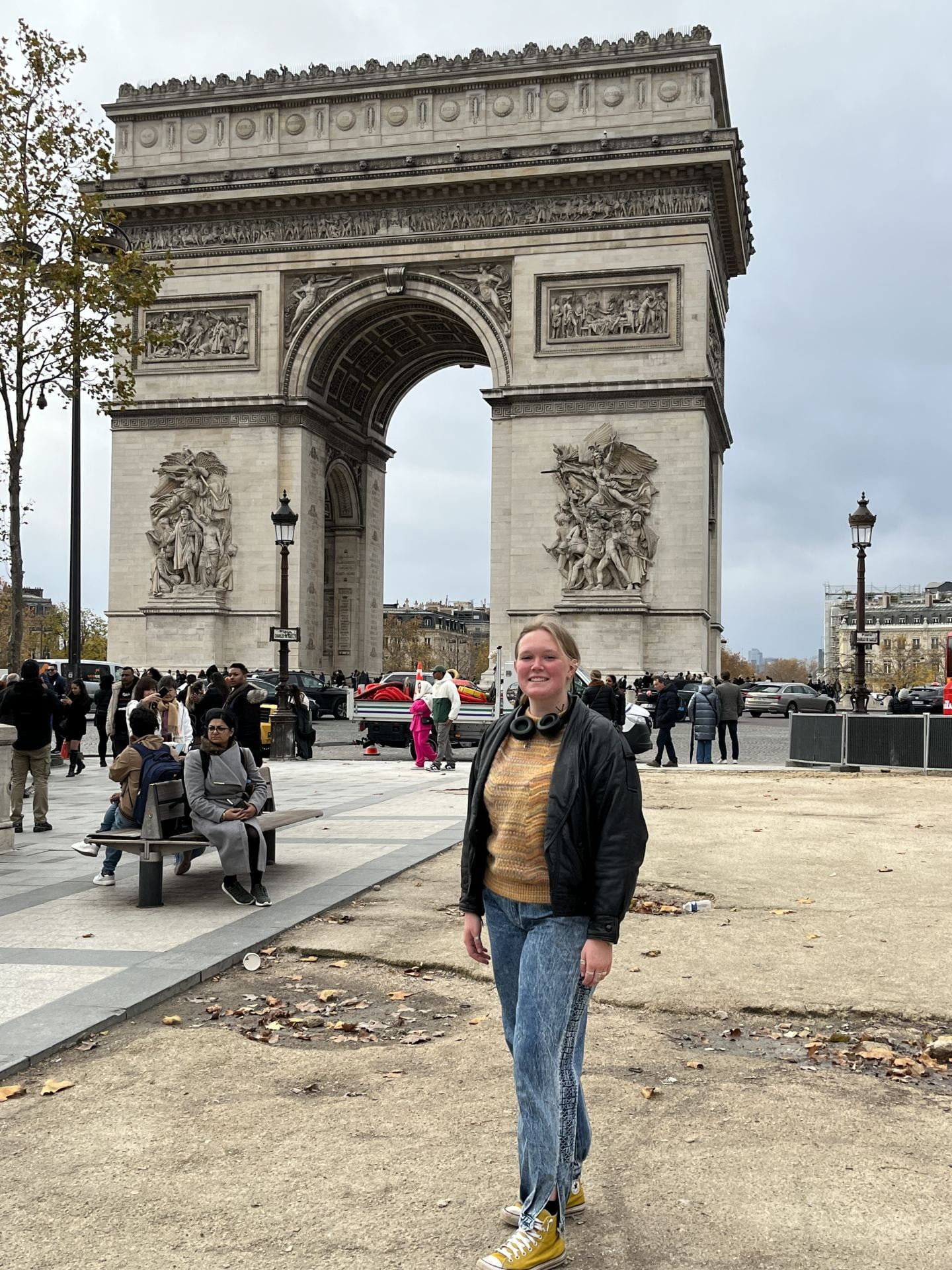a smiling New Paltz student standing in front of L'arc de triomphe in Paris, France