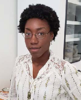 a person with short brown hair and glasses wearing a white blouse