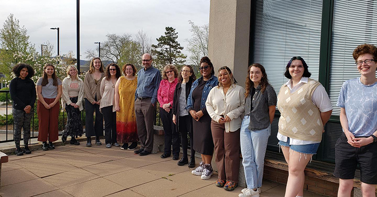 students and faculty outside on the College Theatre patio