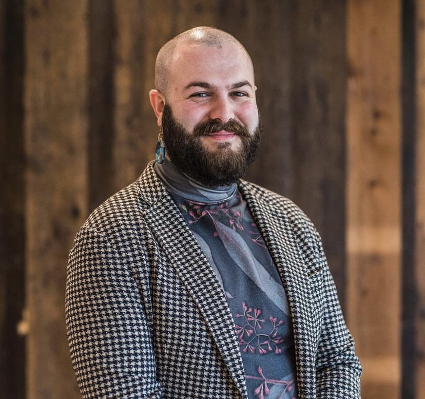 person with beard, houndstooth jacket and blue shirt smiley