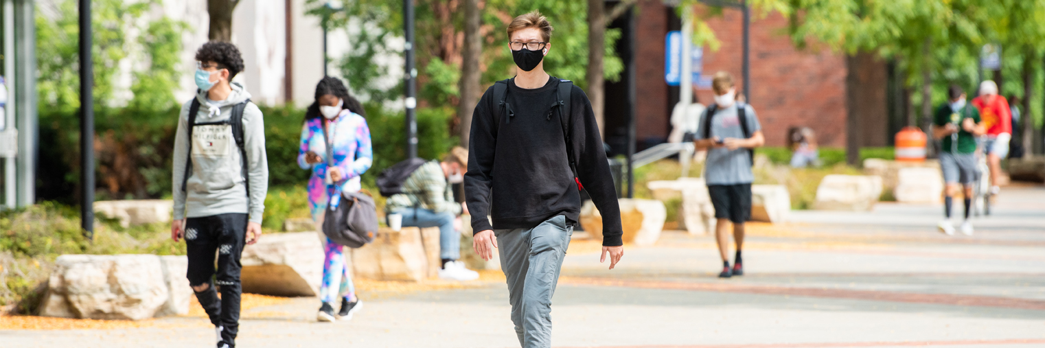 students walking on campus with masks, practicing social distancing