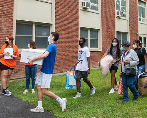 Parent and students at a dorm building