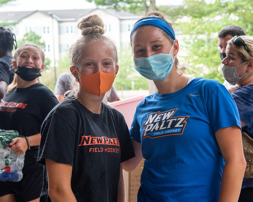 Two students with masks facing camera