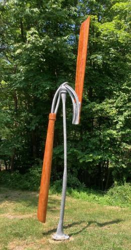 A wood and metal windmill like sculpture.
