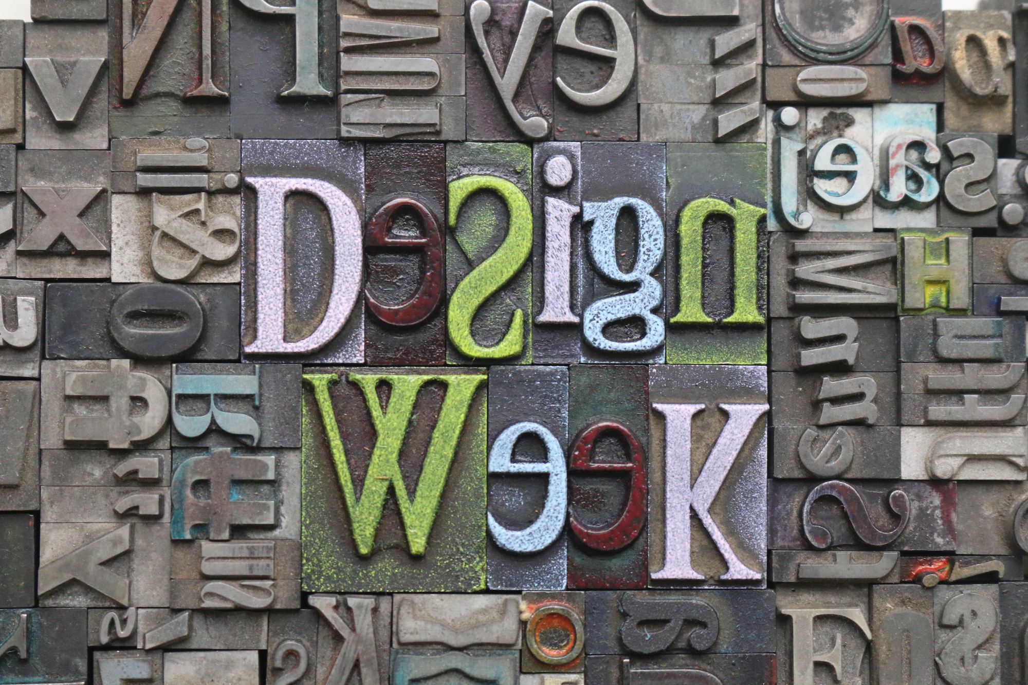 metal letters and characters tightly spaced together with the words Design Week inked