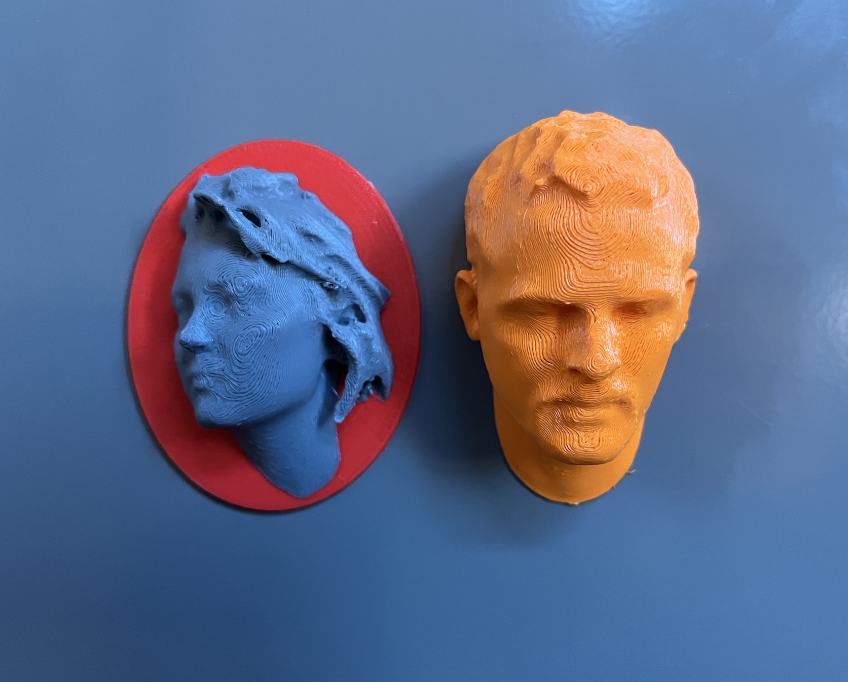 two 3D printed heads from 3D scans in blue and orange