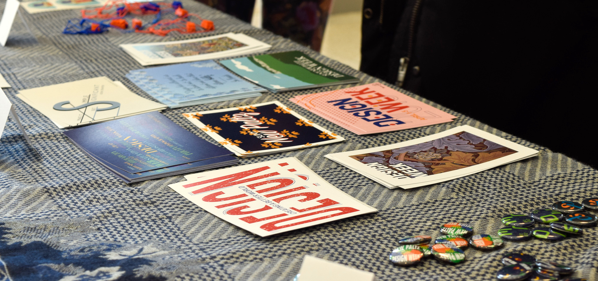 colorful postcards and buttons designed by students on a table