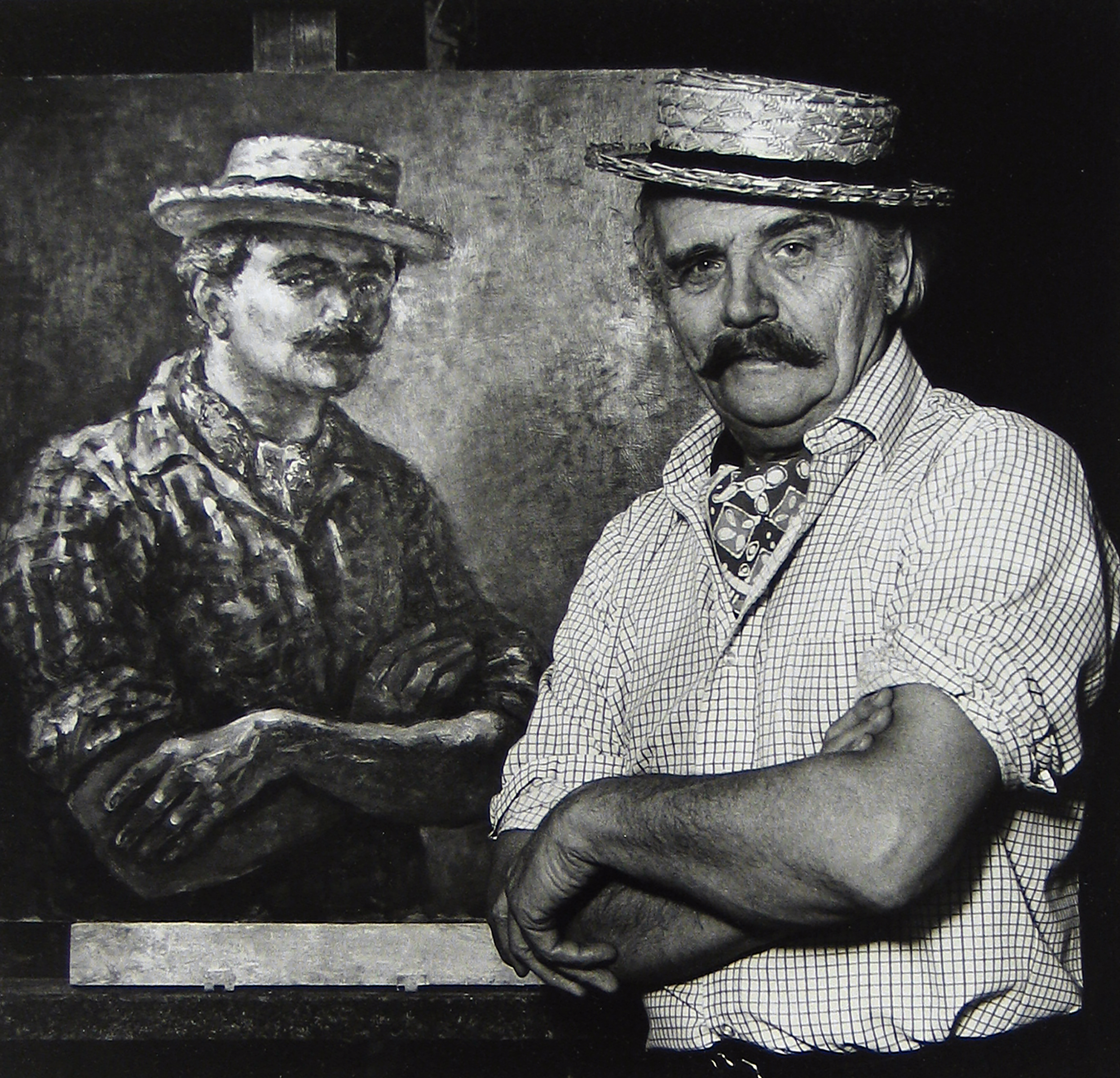 Man in hat sitting in chair next to portrait painting