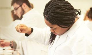 A student holding an eye dropper